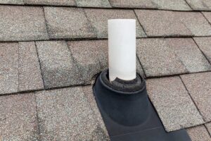A homeowner inspecting loose shingles and damaged flashing beside a roof ladder.